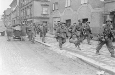 Angehörige der 11. Panzerdivision mit befreiten KZ-Häftlingen in Linz, 7. Mai 1945. (Foto: US Signal Corps Foto; Courtesy of NARA)