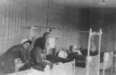 Nurses of the 131st Evacuation Hospital caring for patients in the former SS-Barracks, Camp Gusen I, May 1945. (photo credits: priv. coll. of Mrs. Mary Traub, 2nd Lieutenant, 131st Evacuation Hospital; Courtesy of Mary Traub)